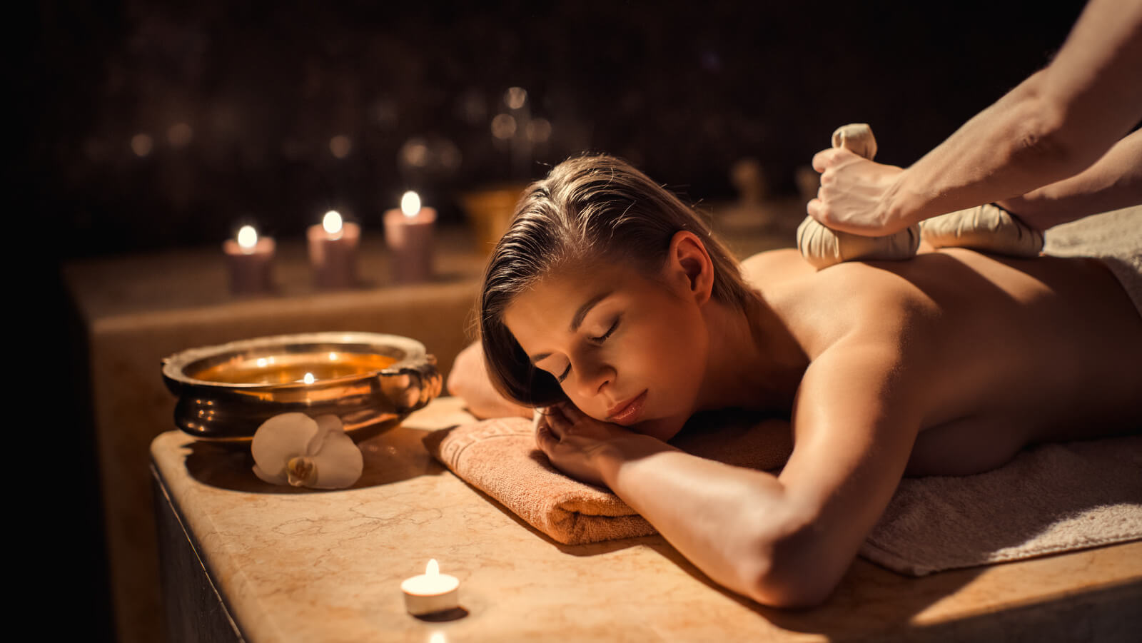 Massage mit Kräuterstempeln