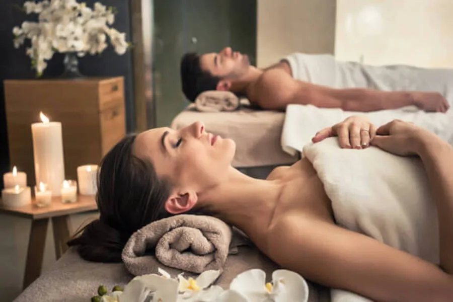 Zwei Personen bei einer Paarmassage mit Kerzen – entspannte Atmosphäre in einem ruhigen Massageraum